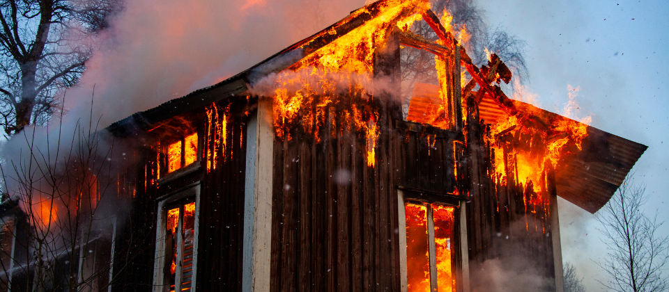Wooden farmhouse under fire.