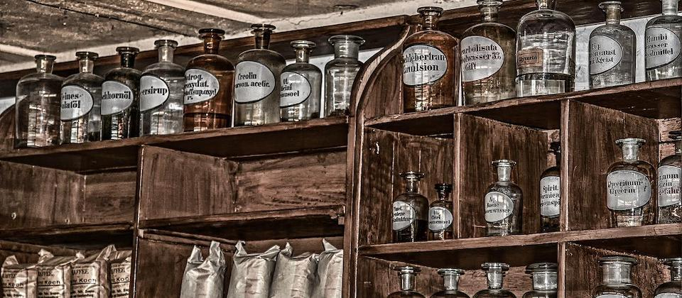 shelves with many antique bottles with white labels