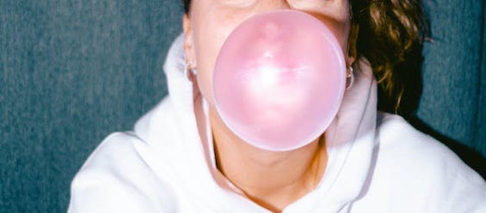 woman with a pink bubble gum bubble