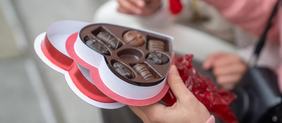  guy giving sweet candies to girlfriend on street