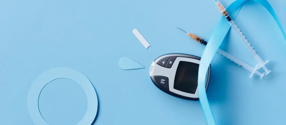 a glucometer, tourniquet, and needles on a blue background