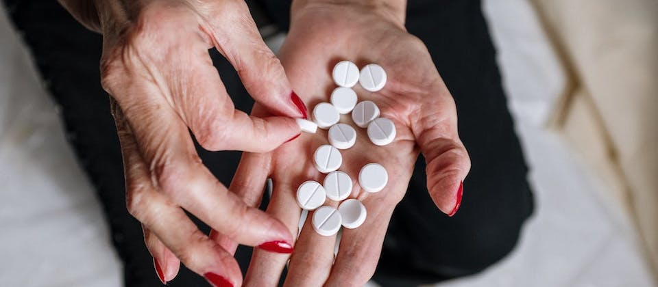 Person Holding White Round Medication Pill
