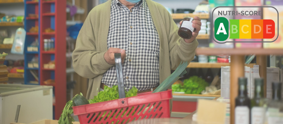 person holding a jar up while grocery shopping, overlaid with nutri-score label