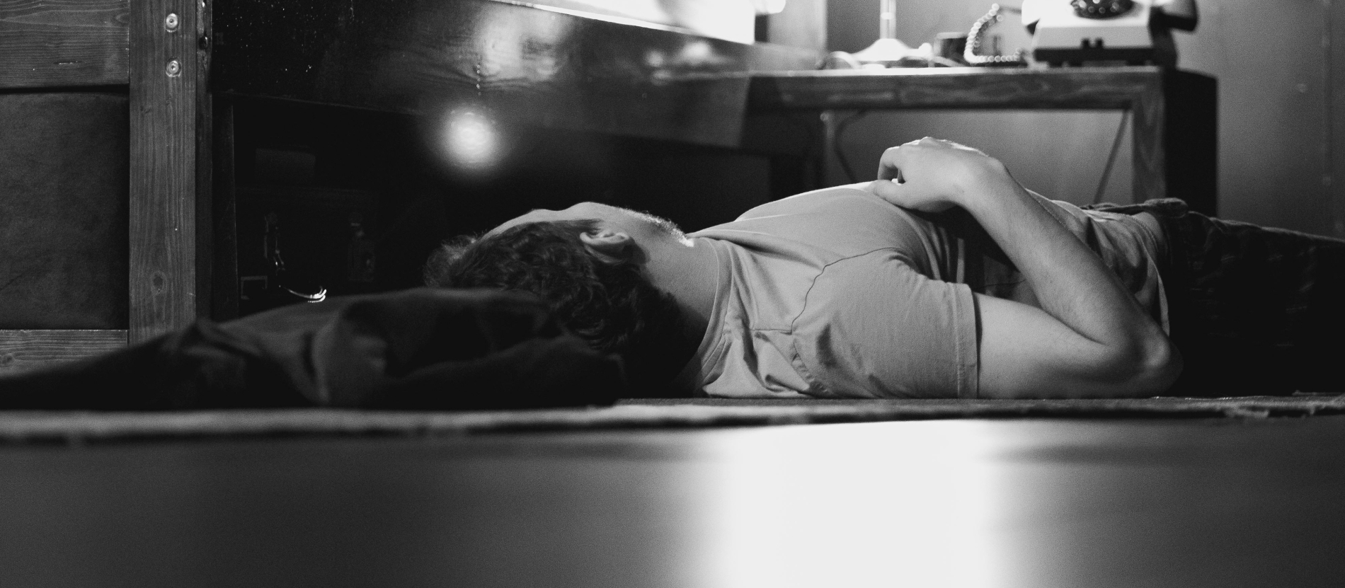 Man sleeping on floor in black and white.