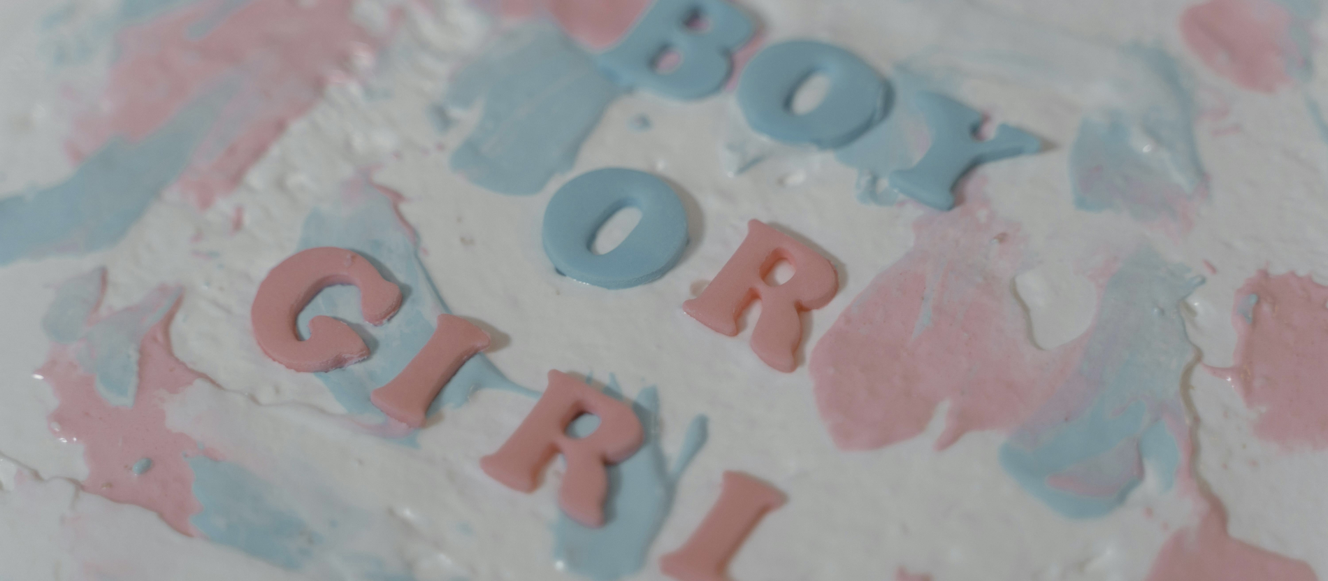 Close-up of gender reveal cake with writing "boy or girl."