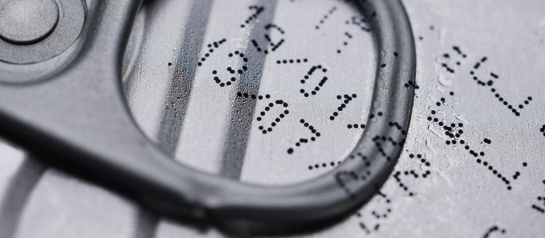 Black and white close-up of expiry date printed on a can.