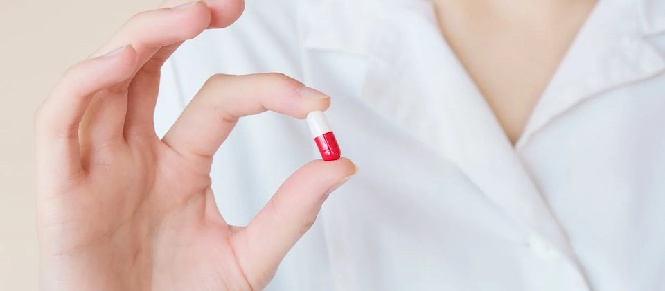Crop nurse demonstrating small double colored pill