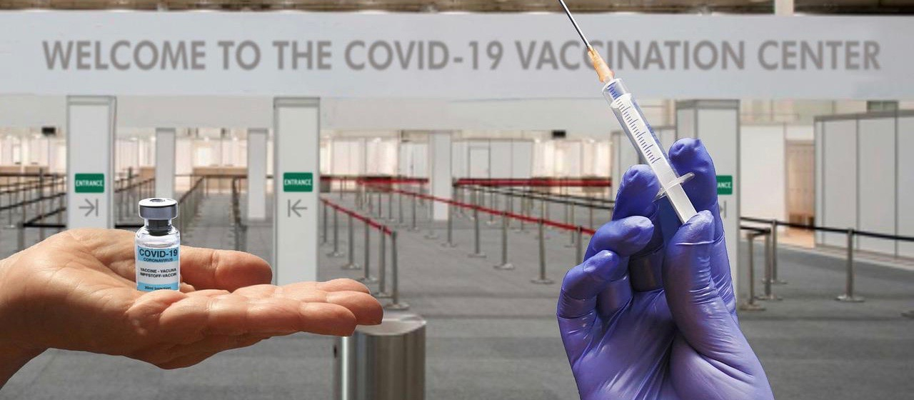 hand holding a vaccine vial with a purple gloved hand holding a ready-to-use needle
