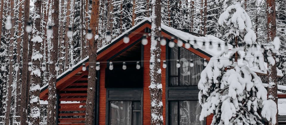 red house in a snow-topped forest