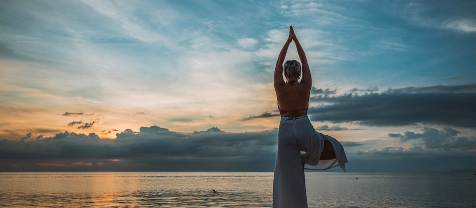 person in yoga pose in the sunset