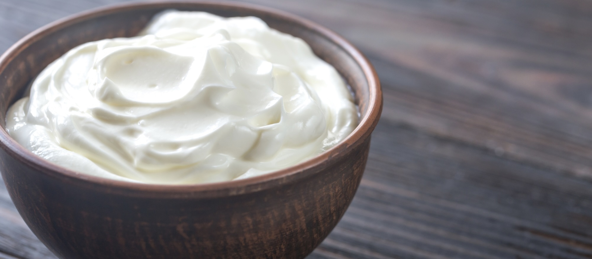 a bowl of yogurt on a wooden table