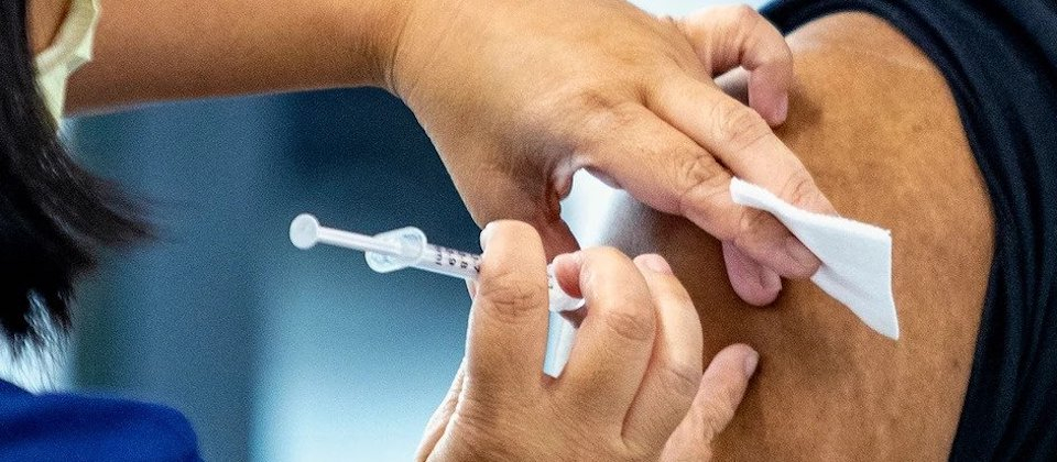 person administering vaccine into someone's upper arm