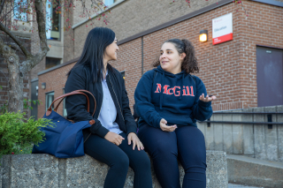 Two Education students sit outside talking