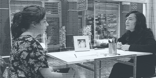 victoria stanton and unknown woman sit across a table from one another