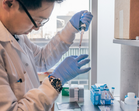 A researcher uses a pipette in a lab