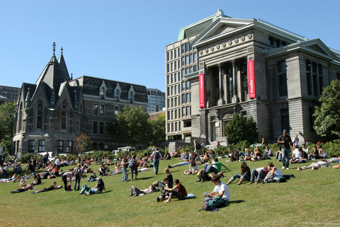 McGill building with students sitting on ground grass