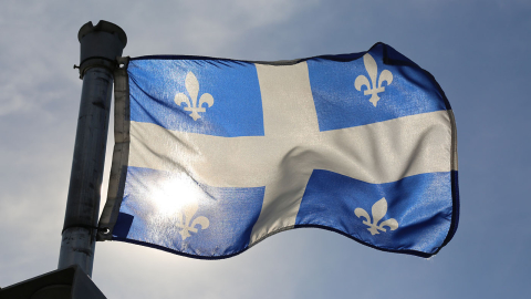 Quebec flag flying against a blue sky