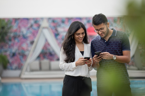 man and woman holding cellphones