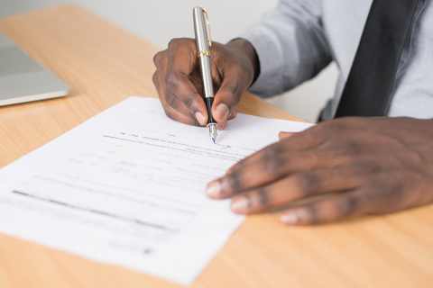 man signing a document