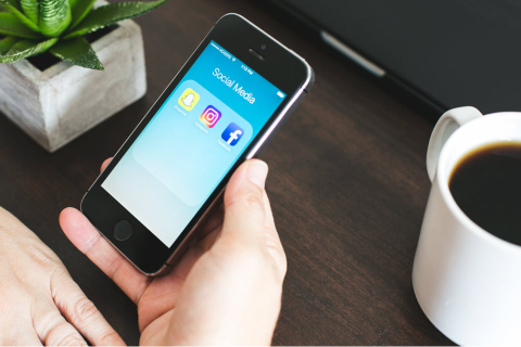social media phone with hand holding it