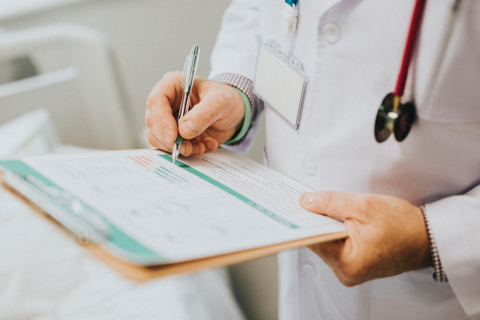 Doctor writing on a clipboard