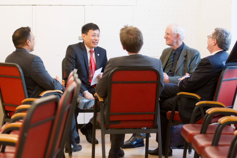 A roundtable discussion between men in suits