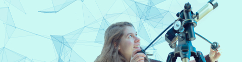 A smiling young woman looking through a telescope