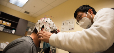 a researcher placing a medical piece of equipment on another person