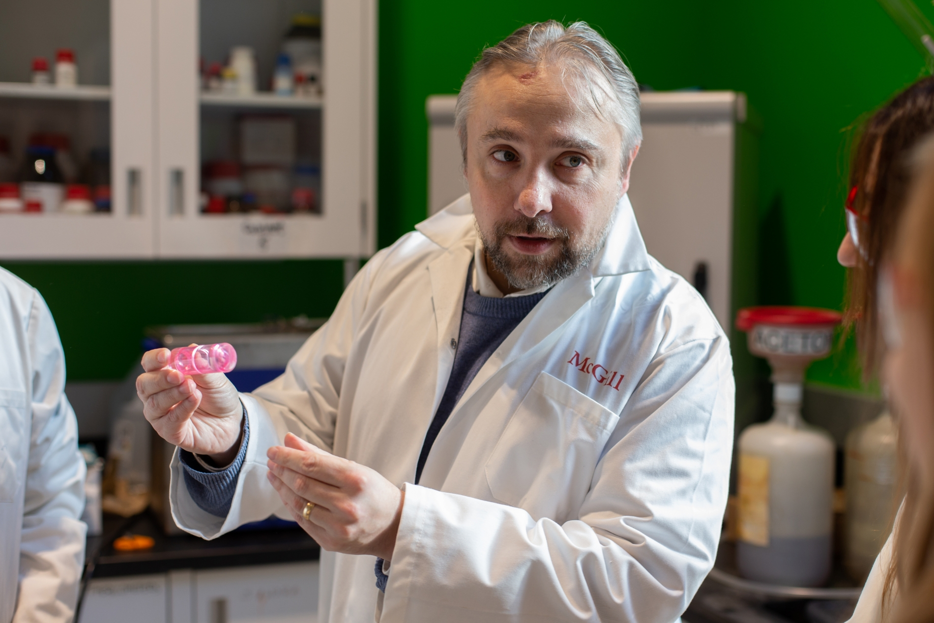 Professor Tomislav Friščić in a lab coat showing his students a vial