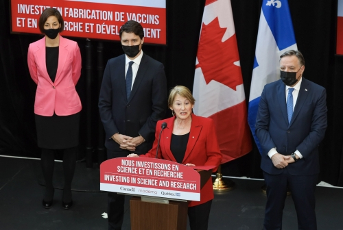 McGill Principal standing at podium with politicians standing behind her on stage.