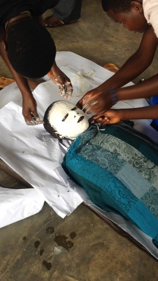 Child with mask plaster on their face as part of a mask making workshop in June 2015 in Uganda. 