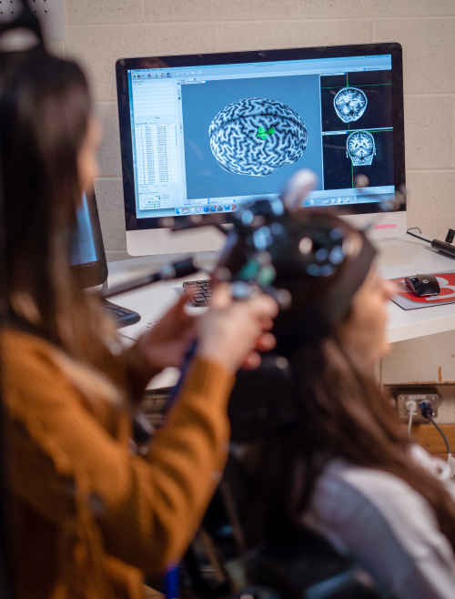 Two women using brain scan equipment