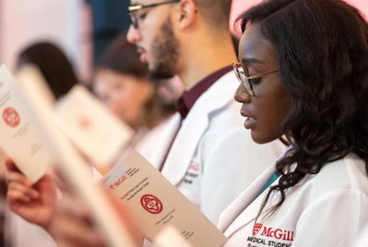 A group of people attending the white coats ceremony
