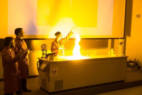 Graduate student leading fiery chemistry demonstration in auditorium