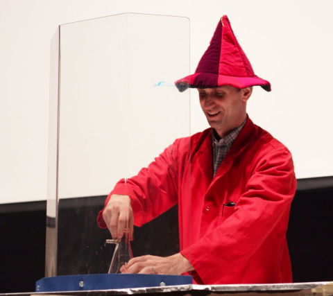 Alex Wahba dressed in wizard's costume performing chemistry demonstration