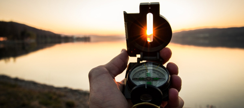 Holding a compass with the sunset in the background Holding a compass with the sunset in the background