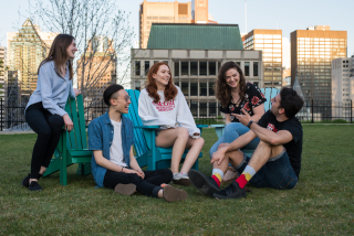 Five students sitting in the grass on the McGill campus