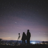 Two people setting up a camera to stargaze