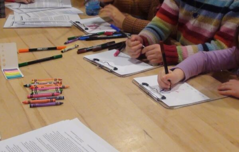 Students with pen and paper drawing on the table 