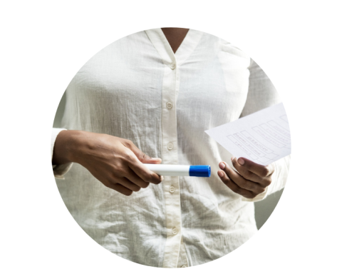 Close up of a woman's hands holding a whiteboard marker and a piece of paper