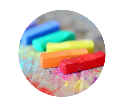 rainbow coloured oil pastels lying on a desk