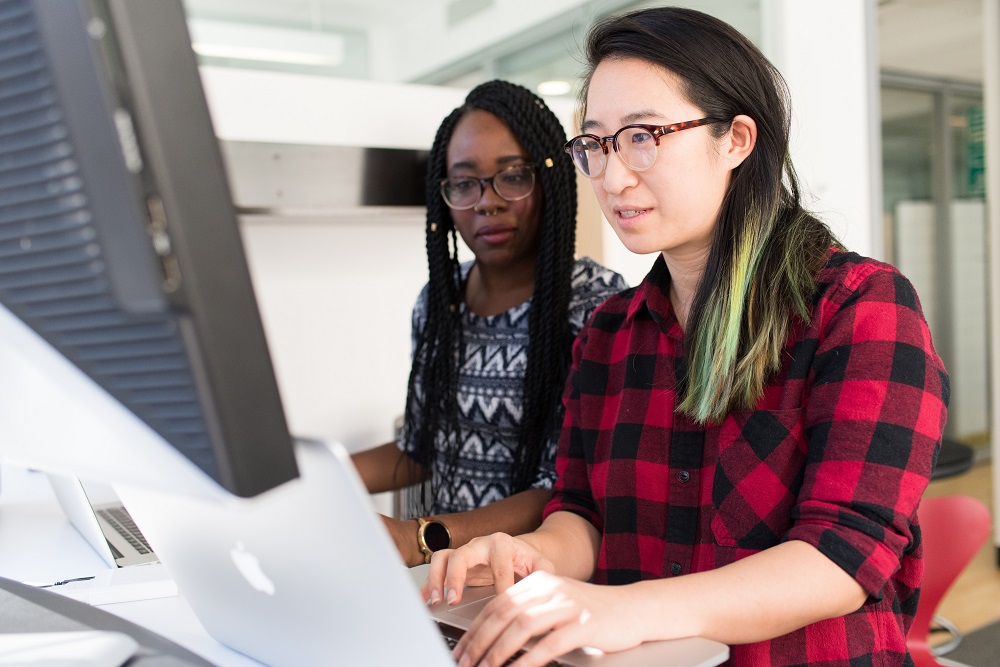 Two people sitting in front of a computer