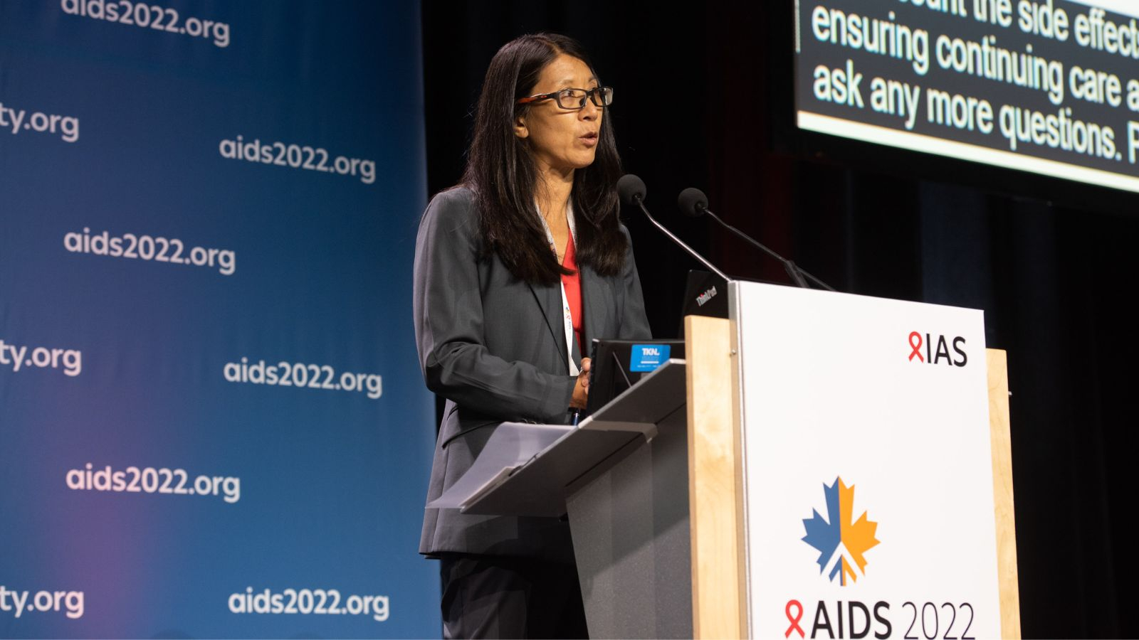 Joanne Liu at the AIDS 2022 podium gives opening remarks at session on HIV in armed conflicts