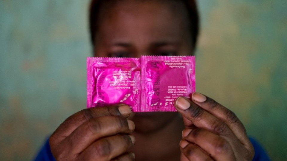 A sex worker conceals her face with a pack of condoms in the Katosi fishing village in Mukono, located east of Kampala, Uganda’s capital (October 24, 2019).