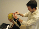 A researcher is placing an EEG cap on a woman