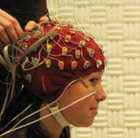 A woman is wearing an EEG cap
