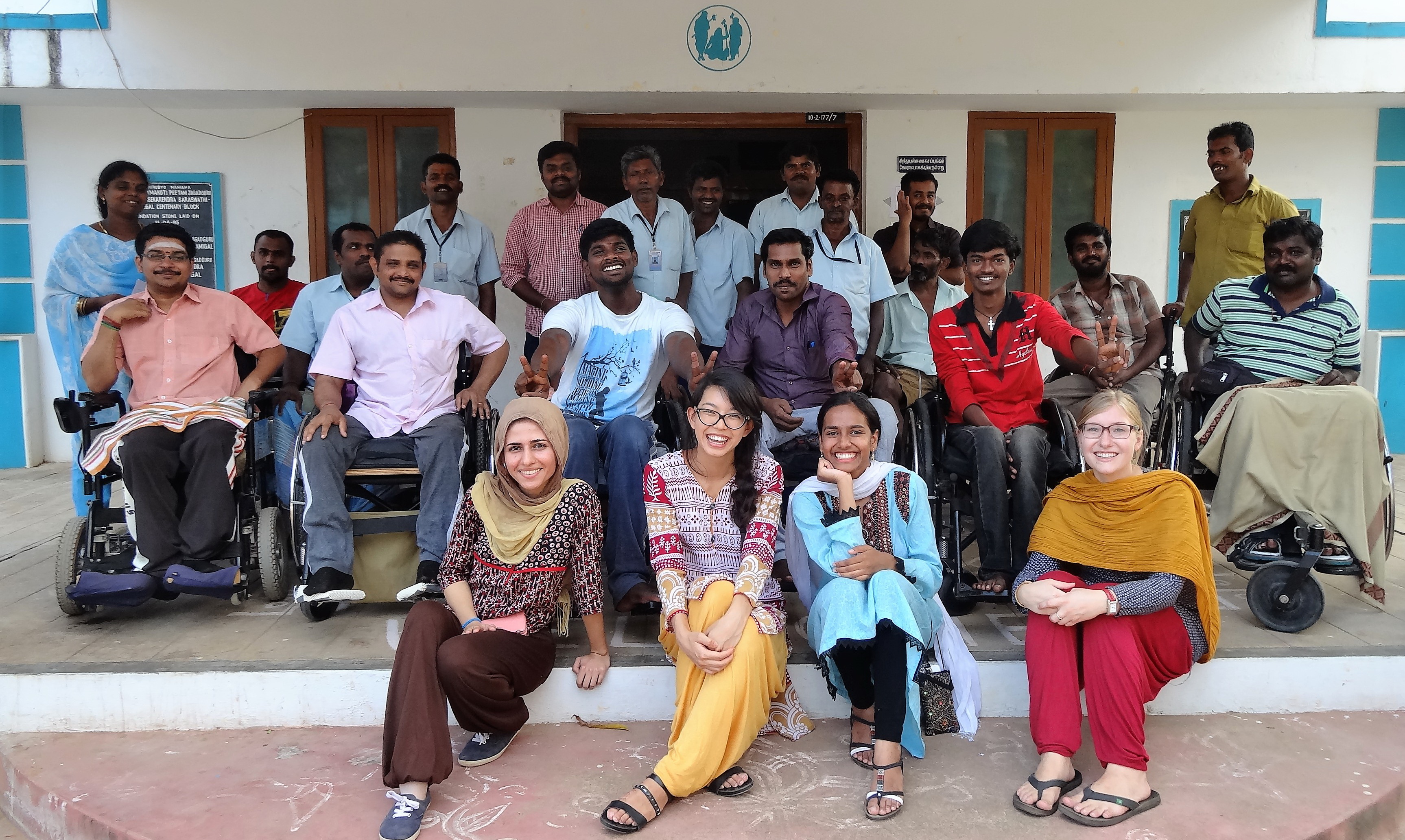 Group of people at seated in front of building in ASSA, Tamil Nadu, India 