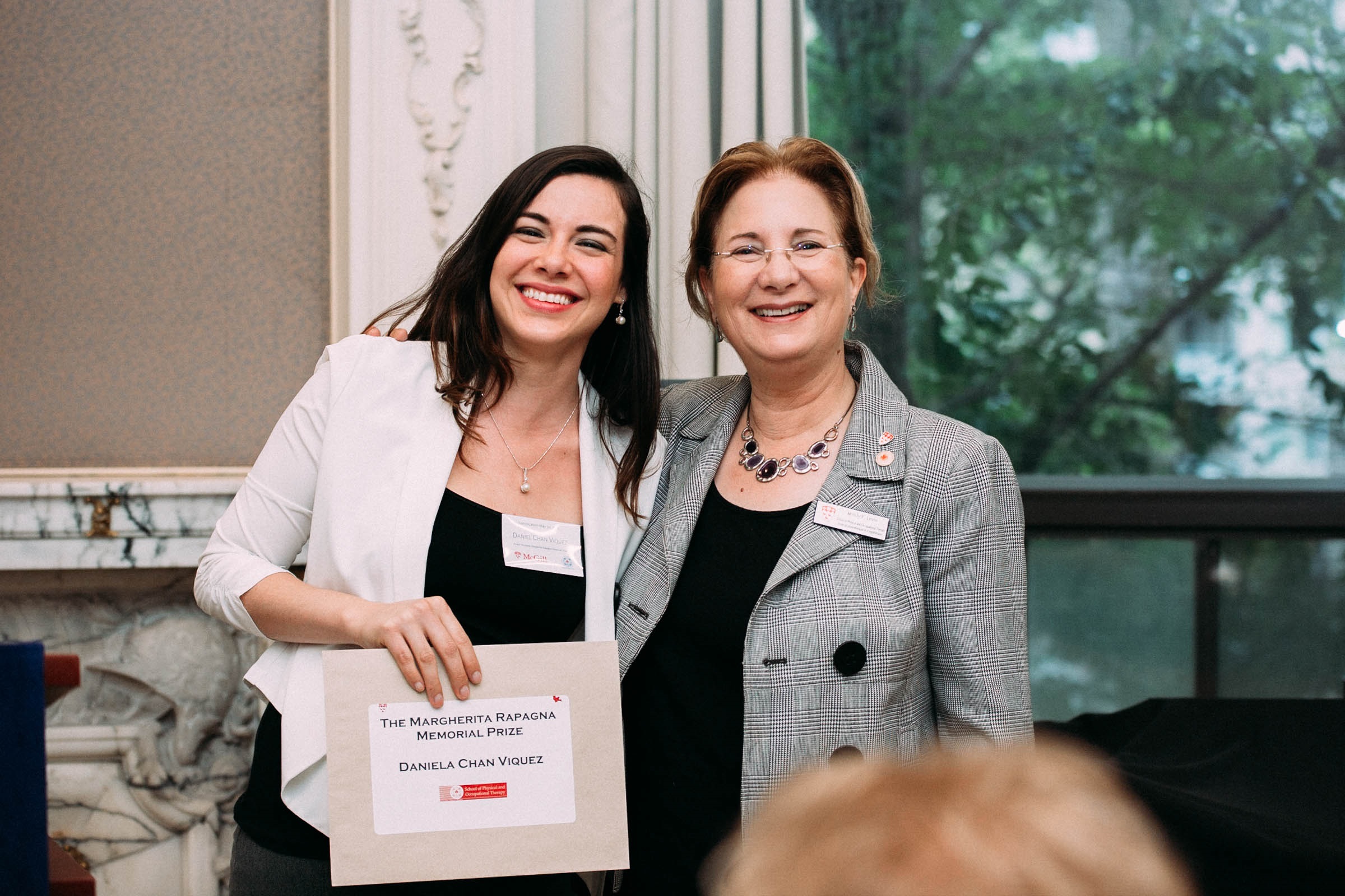 two people standing, prize recipient on left