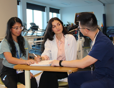 Two PT supervisors sitting with a PT student 