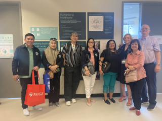 A group of people pose in front of SBNH wall display